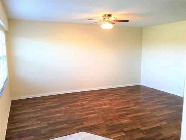 a view of a big room with wooden floor and fan