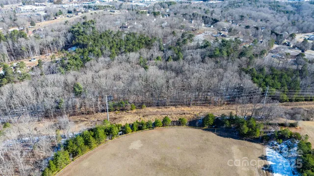 an aerial view of residential houses with outdoor space and trees