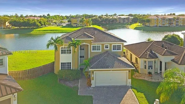 an aerial view of a house with a garden and lake view