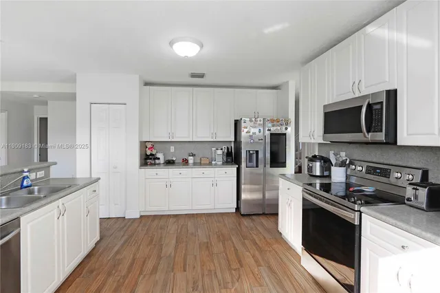 a kitchen with a sink a stove top oven and refrigerator