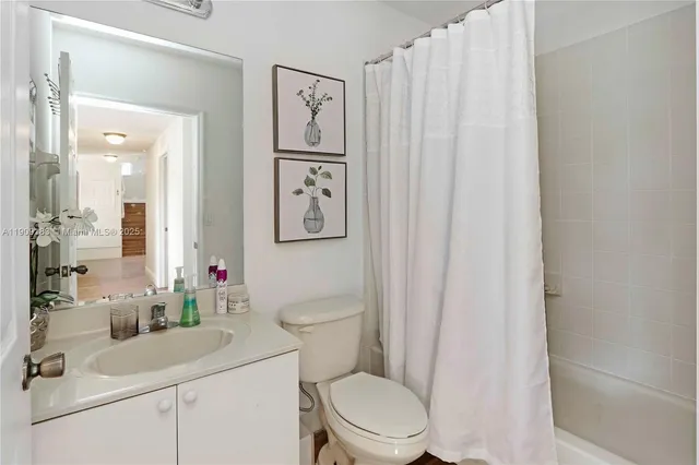 a bathroom with a toilet sink vanity and mirror