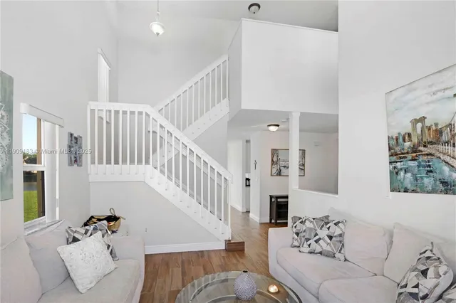 a living room with furniture and stairs