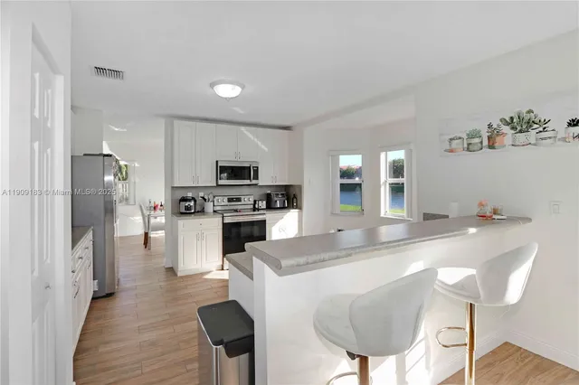 a kitchen with white cabinets and stainless steel appliances