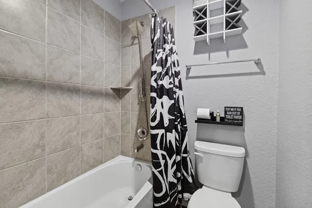 a white toilet sitting next to a bath tub