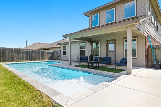 a view of a house with backyard and sitting area