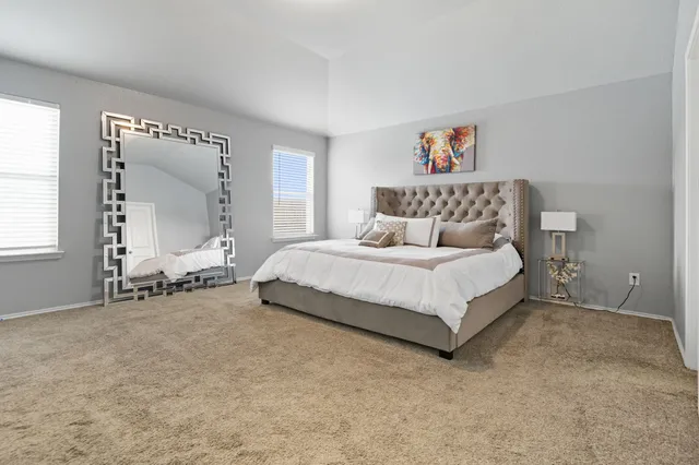 a bedroom with a bed and a large window