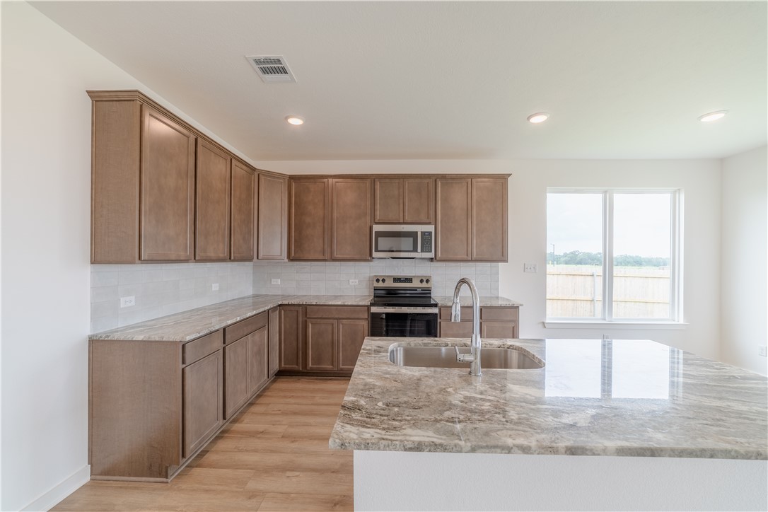1901 Sebright Drive Bryan, TX 77807 - Photo 6 of 13 a kitchen with stainless steel appliances granite countertop a sink stove and refrigerator