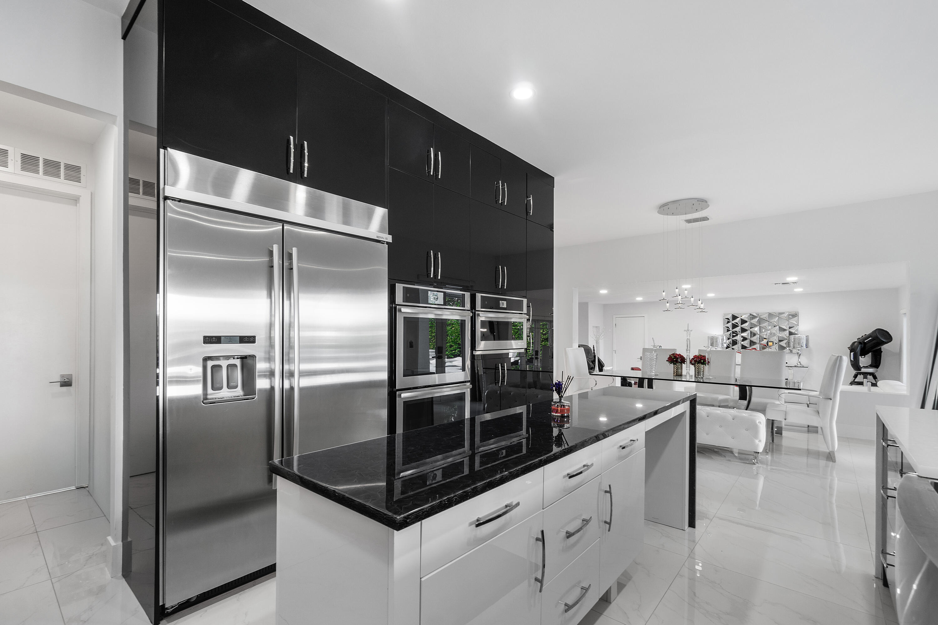 5447 Center Street Jupiter, FL 33458 - Photo 14 of 60 a kitchen with stainless steel appliances kitchen island granite countertop a refrigerator a sink a stove and cabinets