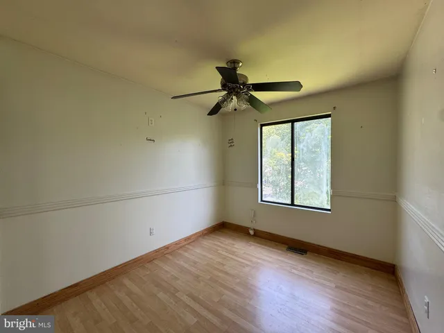 an empty room with a window and a fan