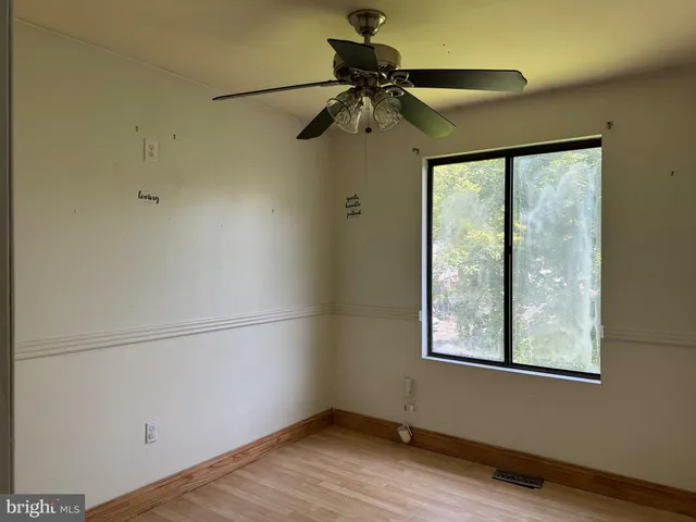 a view of a room with a large window and wooden floor
