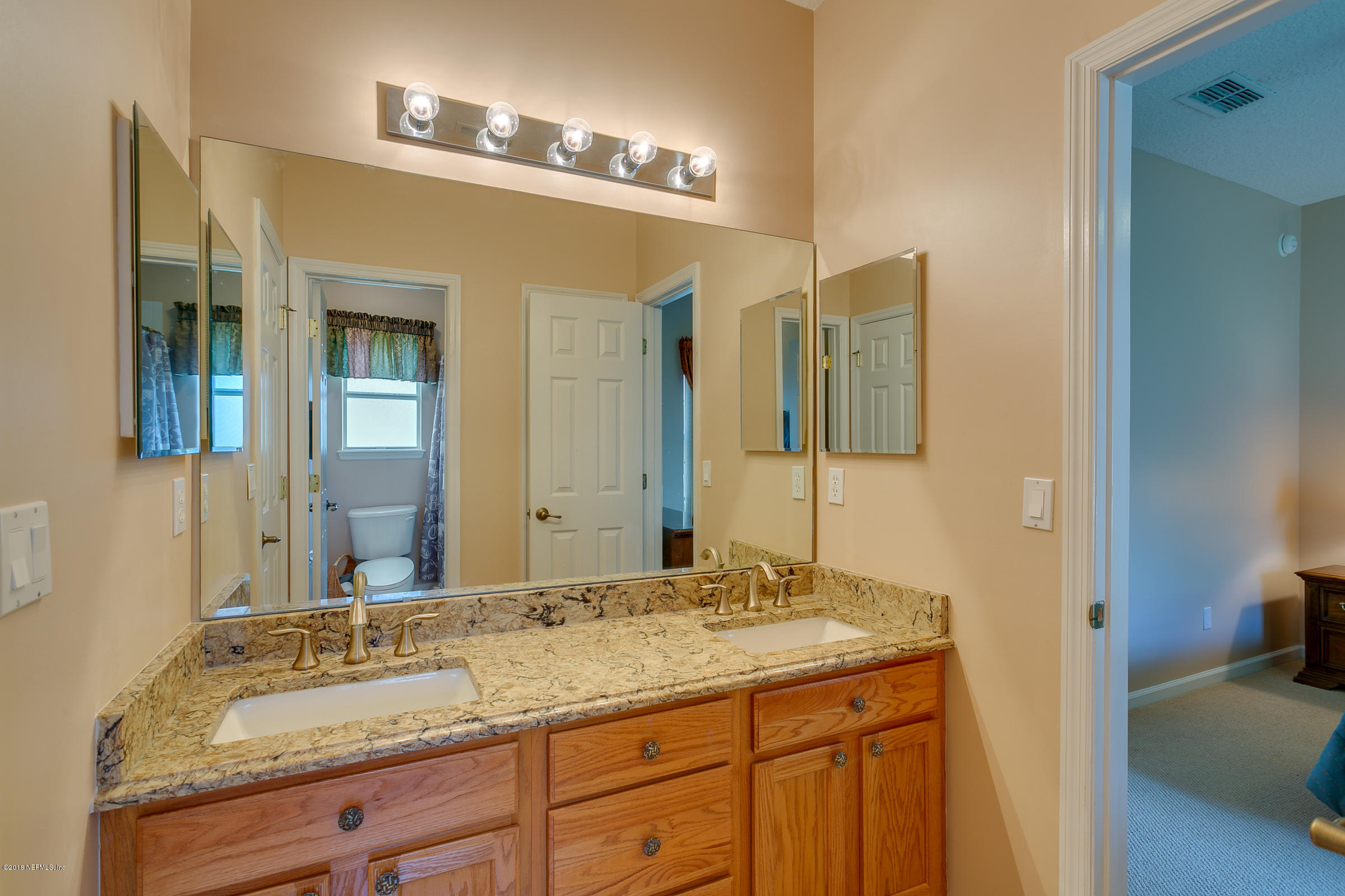 1925 Lyndhurst Drive St. Augustine, FL 32092 - Photo 32 of 52 a bathroom with a granite countertop double vanity sink and a mirror
