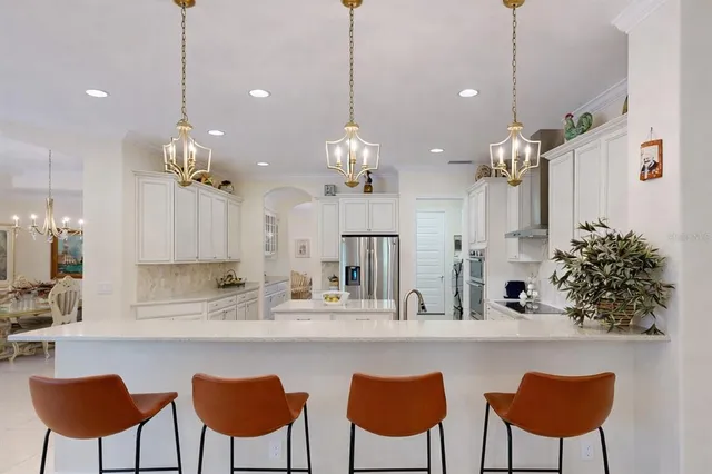 a living room with furniture kitchen view and a large window