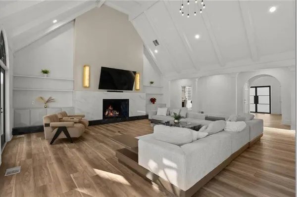 a living room with furniture a flat screen tv and a fireplace