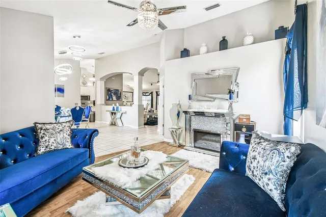 a living room with furniture a fireplace and a chandelier