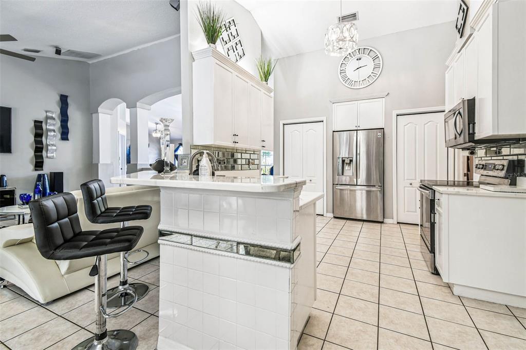 9804 Ocasta Street Riverview, FL 33569 - Photo 25 of 80 a living room with stainless steel appliances furniture a clock and a kitchen view