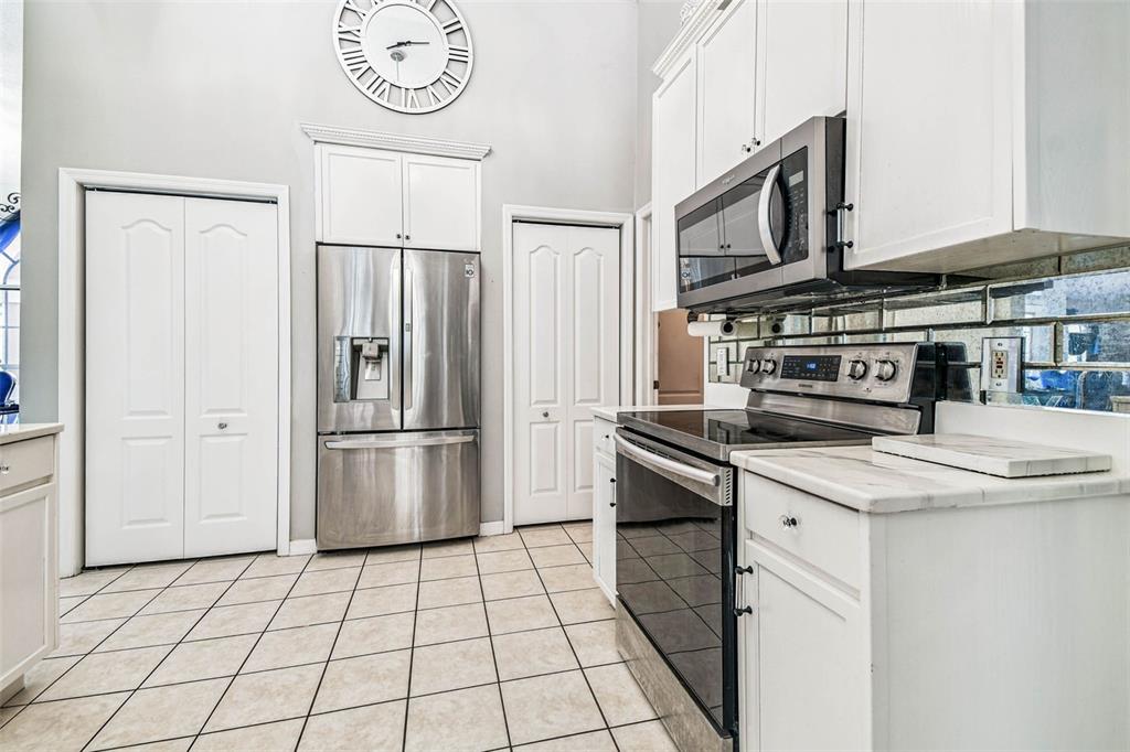 9804 Ocasta Street Riverview, FL 33569 - Photo 27 of 80 a kitchen with stainless steel appliances a refrigerator a stove a sink and a microwave