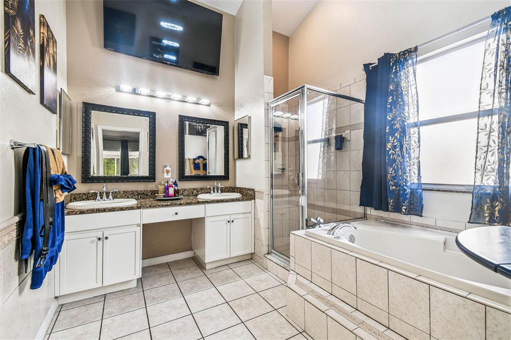 9804 Ocasta Street Riverview, FL 33569 - Photo 34 of 80 a bathroom with a granite countertop sink mirror and a bathtub