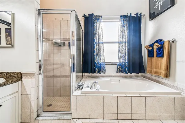 a living room with furniture a flat screen tv and floor to ceiling window