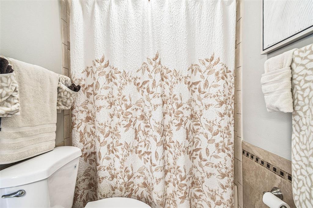 9804 Ocasta Street Riverview, FL 33569 - Photo 46 of 80 a bathroom with a toilet and a shower curtain