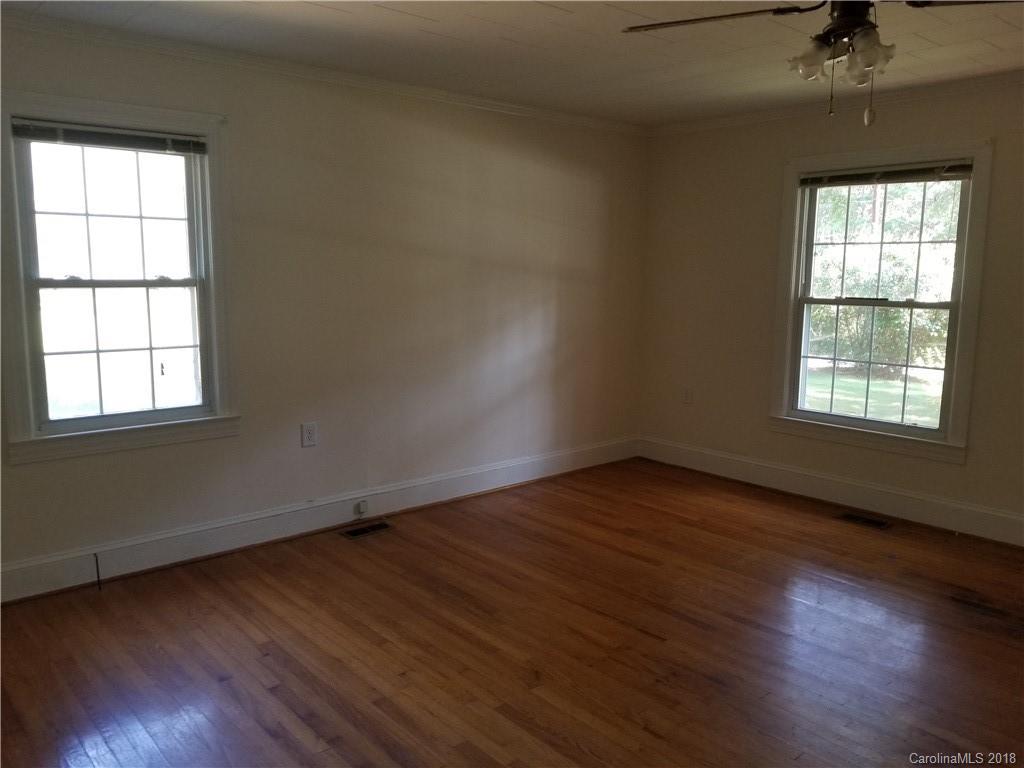 4151 Odell School Road Concord, NC 28027 - Photo 5 of 9 an empty room with wooden floor and windows