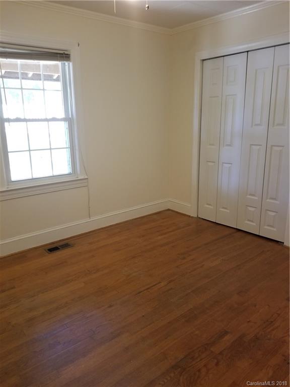4151 Odell School Road Concord, NC 28027 - Photo 8 of 9 an empty room with wooden floor and windows with curtains