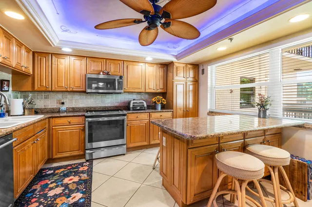 a kitchen with stainless steel appliances granite countertop a sink a stove and a microwave