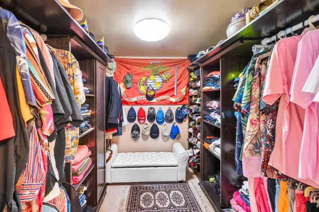 a view of walk in closet with clothes and shoes