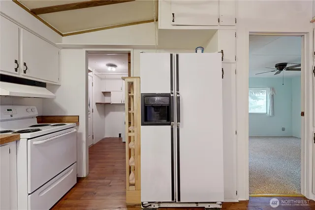 a kitchen with stainless steel appliances a refrigerator a stove and white cabinets