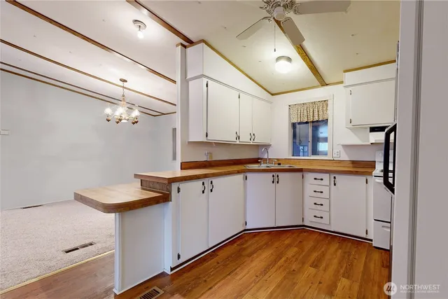 a kitchen with a sink appliances cabinets and a window