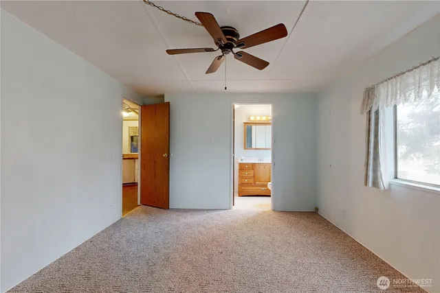 an empty room with closet and windows