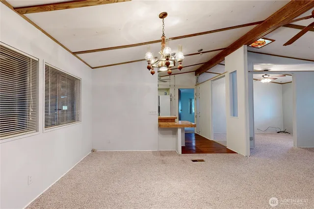 a view of a room with a chandelier and refrigerator