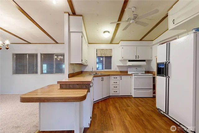 a kitchen with kitchen island granite countertop a sink and refrigerator
