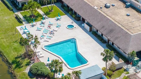 an aerial view of a swimming pool with outdoor seating and yard
