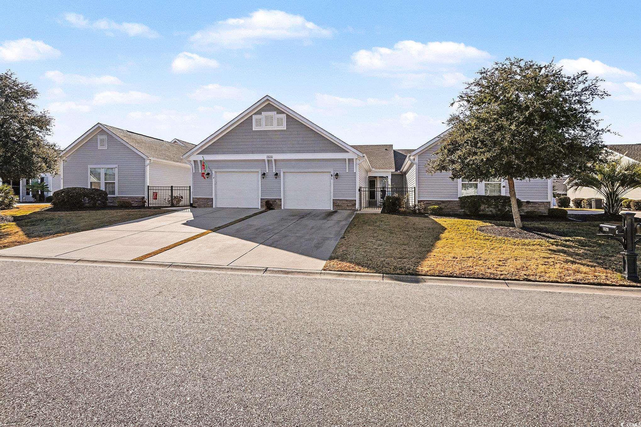 View of front facade featuring stone siding and driveway