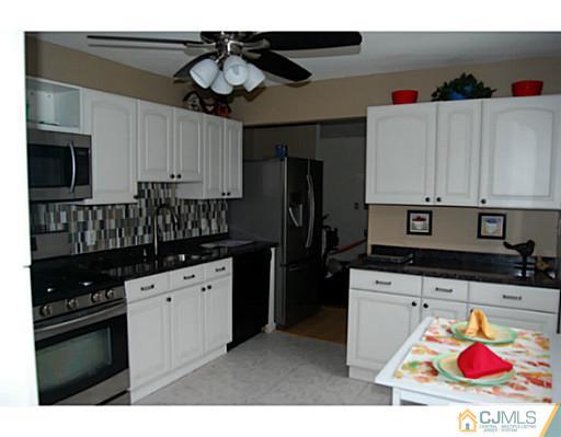 95 Winthrop Road Edison, NJ 08817 - Photo 5 of 25 a kitchen with stainless steel appliances granite countertop a stove refrigerator sink and cabinets