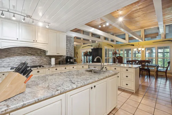 a kitchen with stainless steel appliances granite countertop a sink refrigerator and chairs