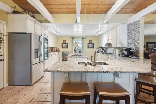 a kitchen with stainless steel appliances granite countertop a sink stove refrigerator and cabinets