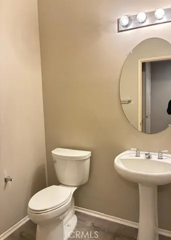 a bathroom with a toilet a sink and mirror