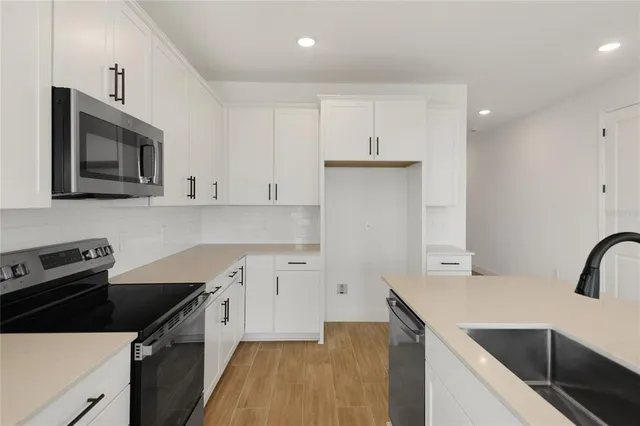 a kitchen with a sink a stove and cabinets