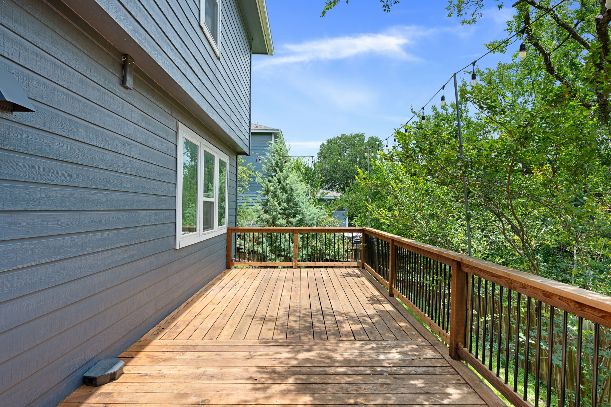 8902 Magna Carta Loop, Unit 122 Austin, TX 78754 - Photo 31 of 39 A spacious wooden deck provides an elevated outdoor retreat amidst lush greenery.