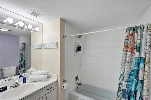 a bathroom with a sink vanity granite tub shower and a mirror