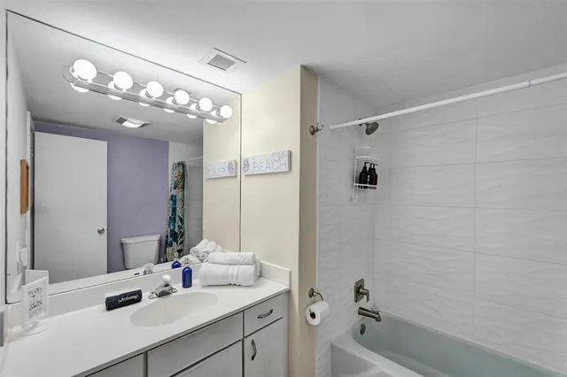 a bathroom with a sink vanity tub and shower