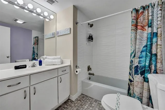 a bathroom with a sink a toilet a mirror a bathtub and shower