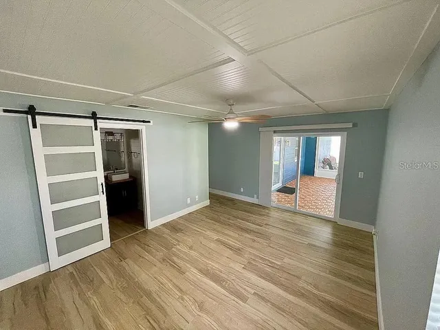 a view of empty room with wooden floor