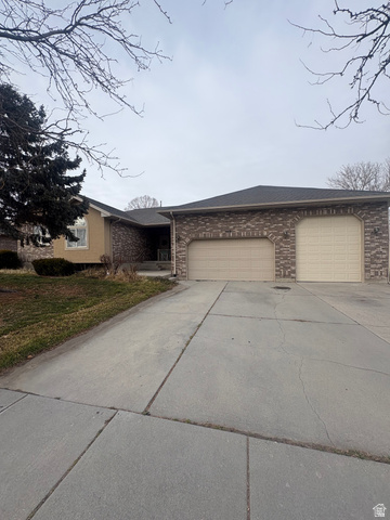 3918 Mapleleaf Way West Jordan, UT 84088 - Photo 1 of 12 View of front facade with driveway, a front lawn, a garage, and brick siding
