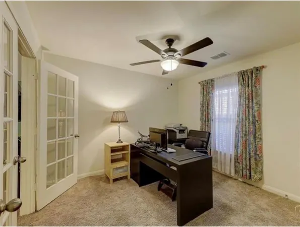 a living room with furniture and a ceiling fan