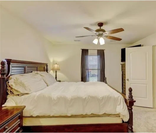 a bedroom with a bed and a ceiling fan