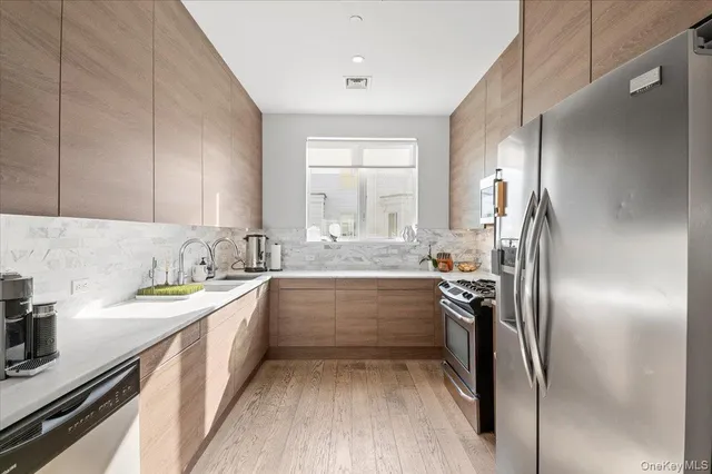 a kitchen with stainless steel appliances granite countertop a sink stove and refrigerator