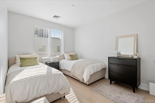 a bedroom with two beds and a dresser