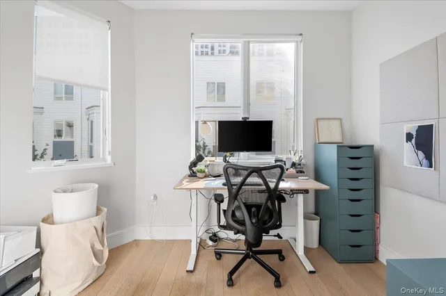 a view of a workspace with furniture and a window
